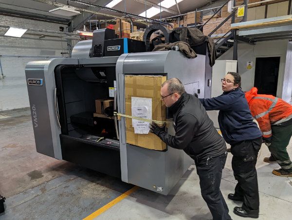 Alan and Rosie help to move the machine into place